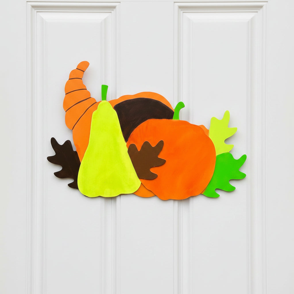 Decorative door hanger with pumpkins and a pear on a gray door