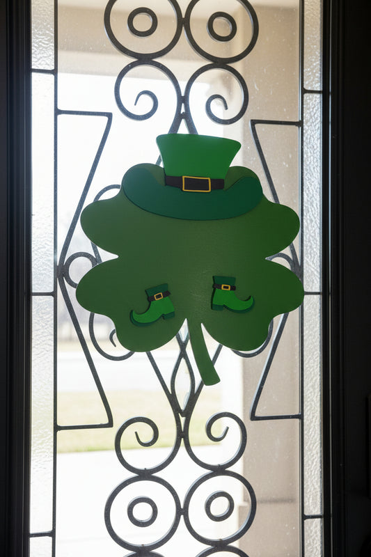 Green shamrock door decoration with a leprechaun hat on a beige door