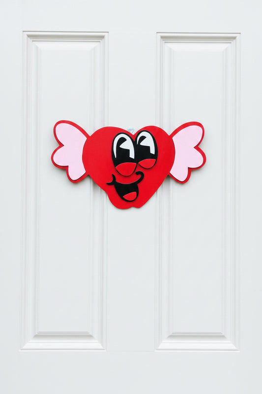 Heart-shaped candy decoration with a face on a gray door