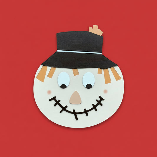Scarecrow face cutout with a black hat on a red background