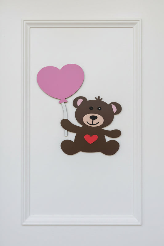 Framed picture of a teddy bear with a pink heart balloon on a white background