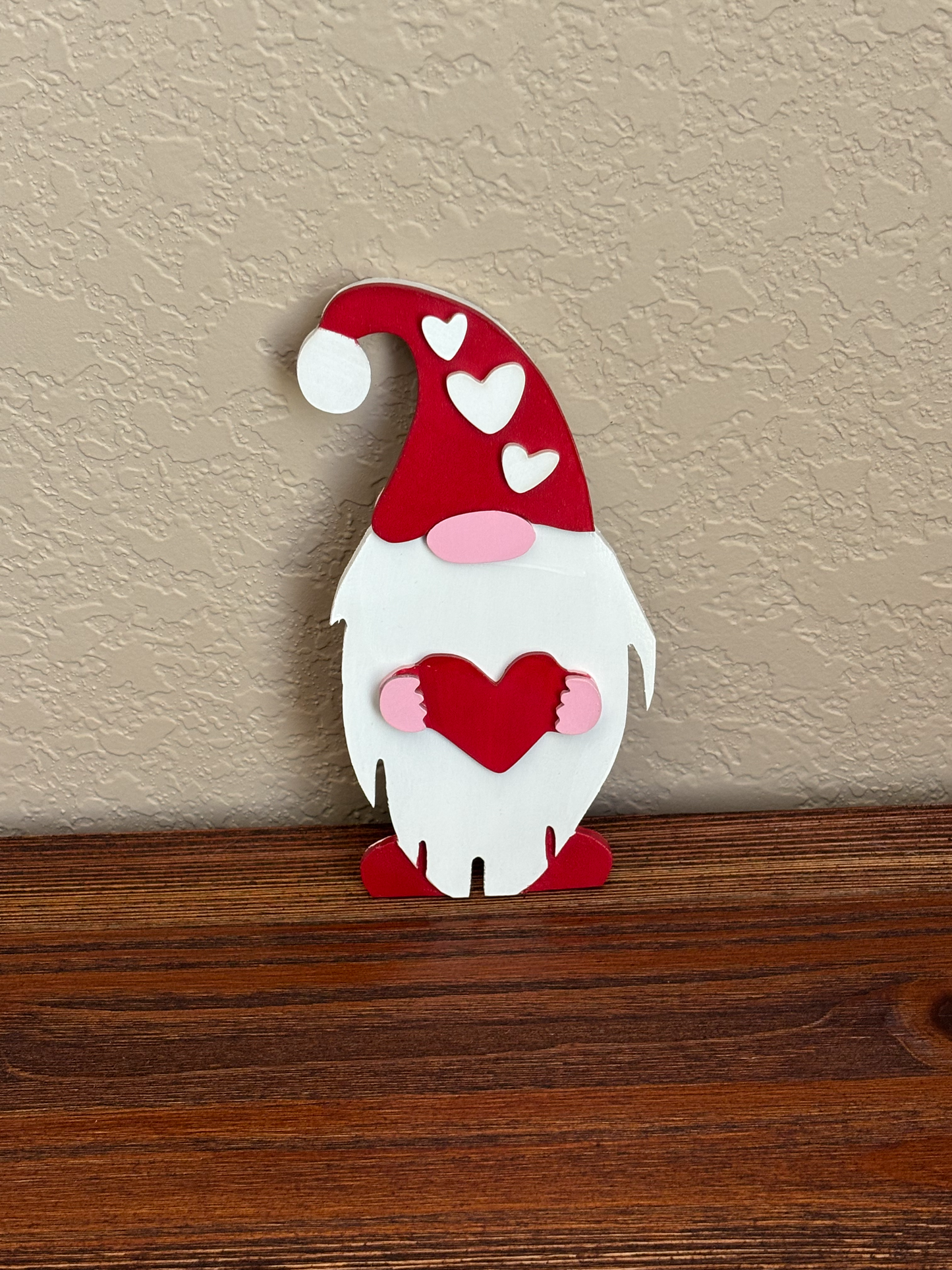 Decorative gnome wall hook with red and white design on a neutral wall.