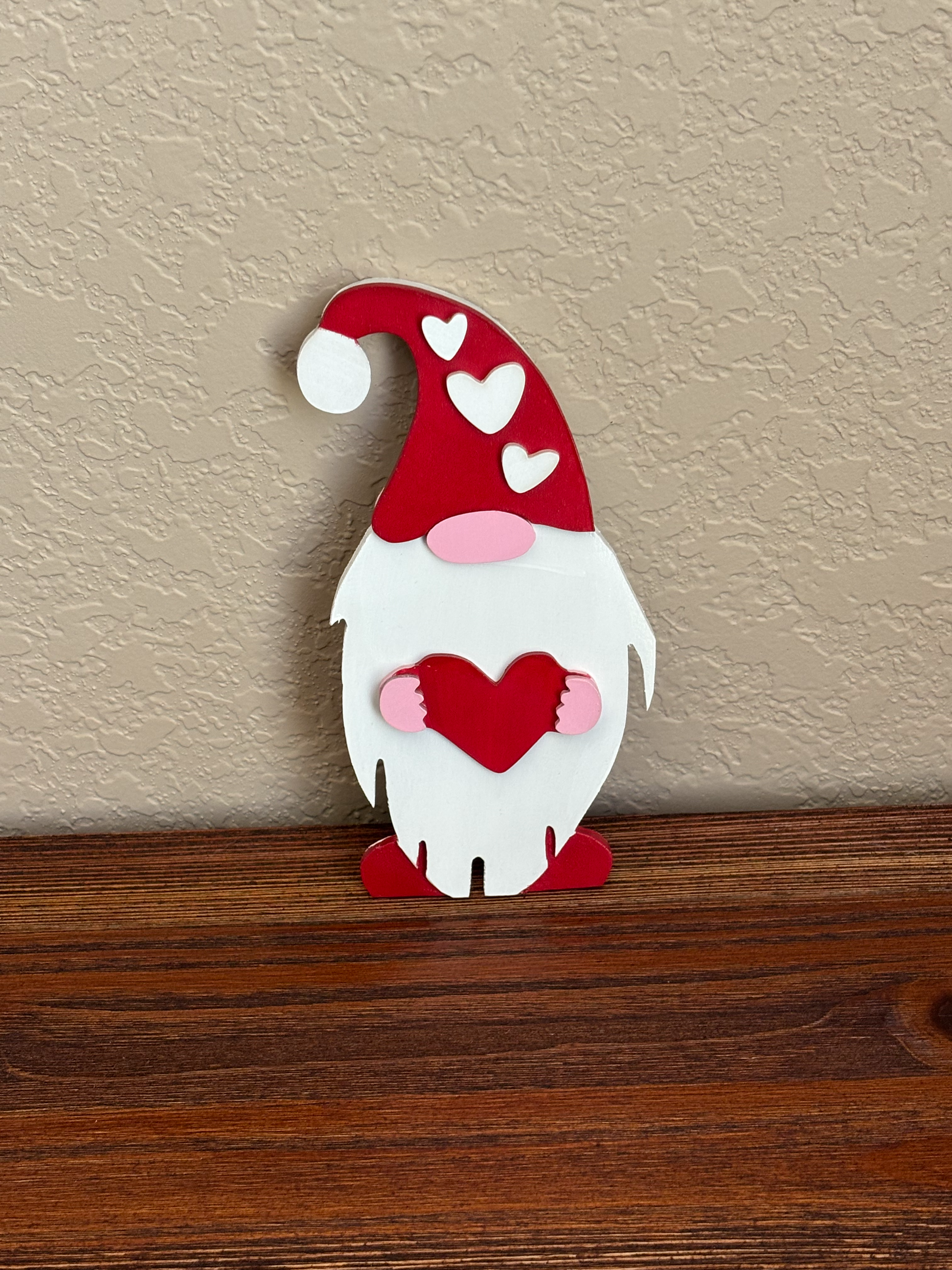 Decorative gnome wall hook with red and white design on a neutral wall.