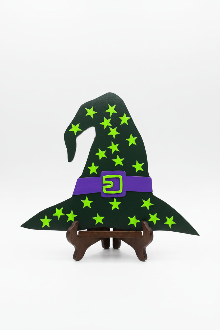 Witch hat decoration with green stars and a purple buckle on a beige door.